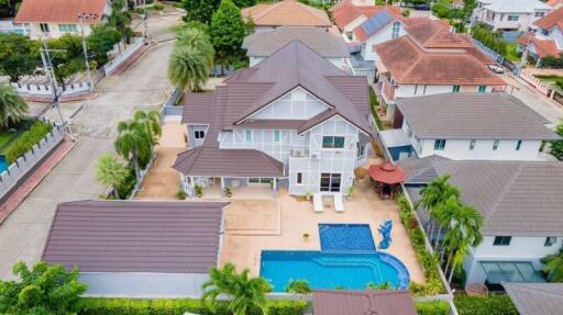 Aerial view of a spacious house with swimming pool and surrounding properties