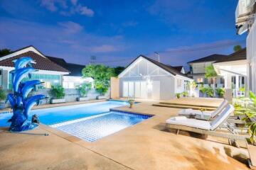 Beautiful outdoor area with a swimming pool and lounge chairs at dusk