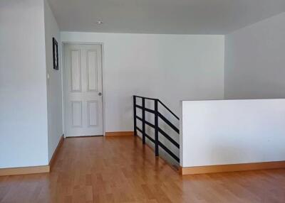 Open space hallway with wooden flooring and white walls