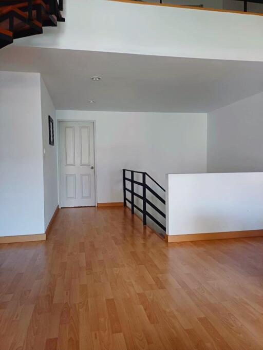 Open space hallway with wooden flooring and white walls