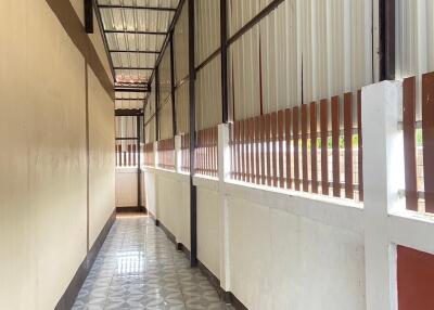 A narrow hallway with tiled floor and metal roof