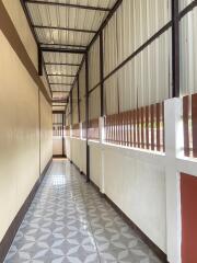 A narrow hallway with tiled floor and metal roof