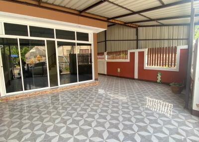 Covered outdoor space with tiled floor and adjacent room