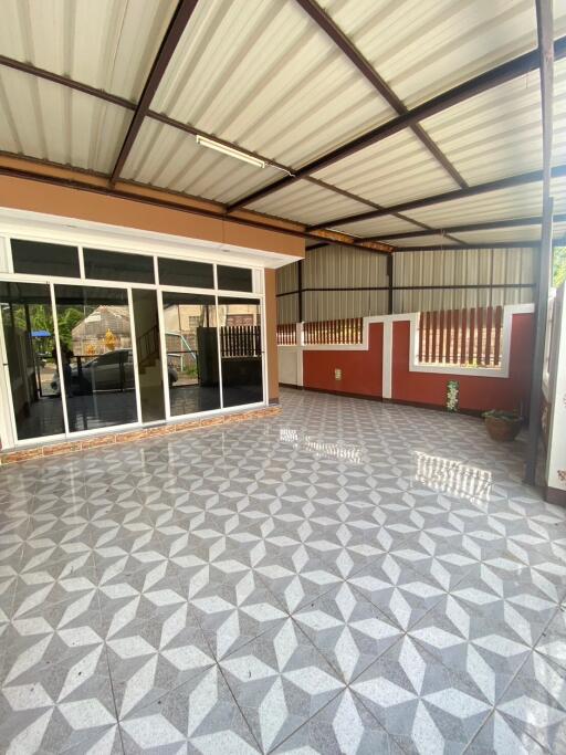 Covered outdoor space with tiled floor and adjacent room