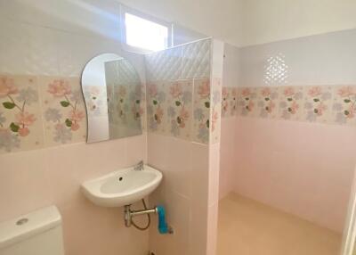 Clean and simple bathroom with floral tiles and essential fittings