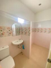 Clean and simple bathroom with floral tiles and essential fittings