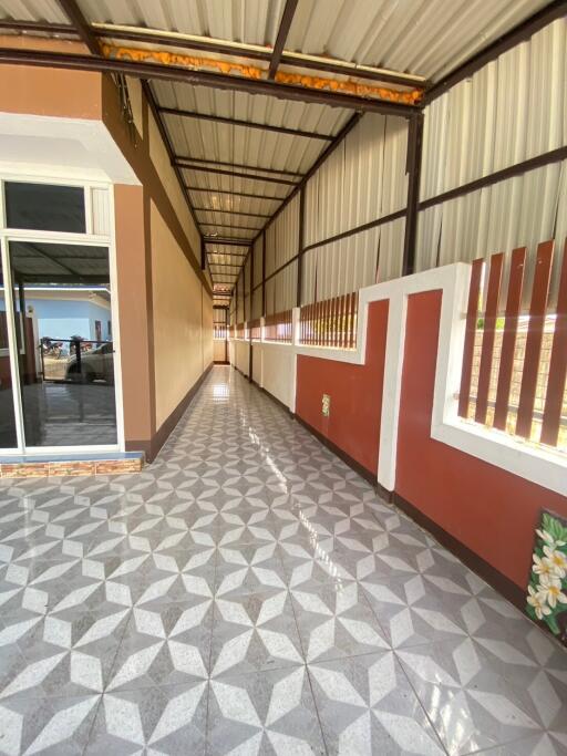 Long corridor with tiled flooring and partially open walls