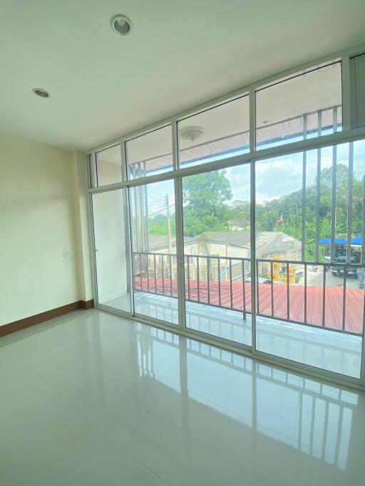 Spacious living room with large windows and balcony