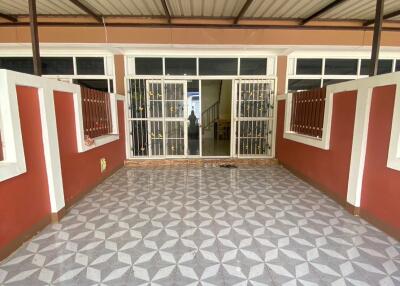 Spacious covered outdoor area with tiled flooring and gated entry