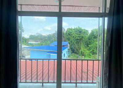 View from a room looking out to a balcony and nearby buildings