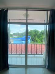 View from a room looking out to a balcony and nearby buildings