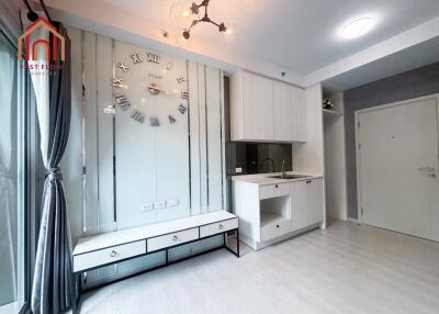 Modern living room with wall clock and kitchenette