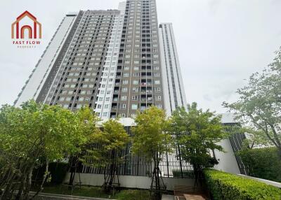 High-rise residential building with surrounding greenery