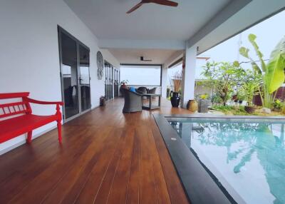 Covered patio with wooden floor and pool