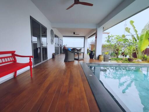 Covered patio with wooden floor and pool