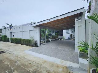 View of a modern residential building with a driveway and carport