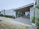 View of a modern residential building with a driveway and carport