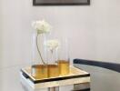 Glass dining table with decorative flowers and framed art on the wall