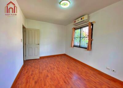 Bedroom with wooden flooring, air conditioning, and natural light