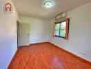 Bedroom with wooden flooring, air conditioning, and natural light