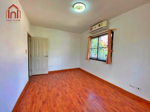 Bedroom with wooden flooring, air conditioning, and natural light