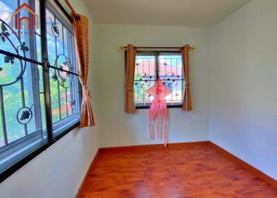 Bright bedroom with wooden flooring and patterned window grills