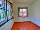 Bright bedroom with wooden flooring and patterned window grills