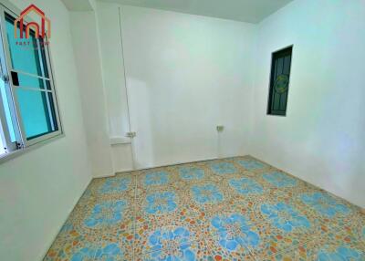 Empty bedroom with tiled floor and windows