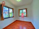 Bright bedroom with wooden flooring and dual windows