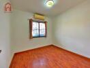 Empty bedroom with wooden floor and air conditioning