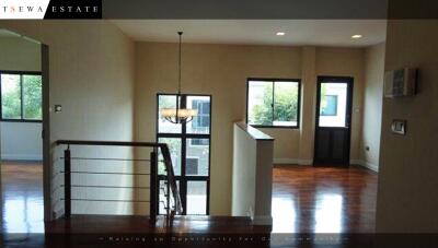 Spacious living room with wooden flooring and large windows