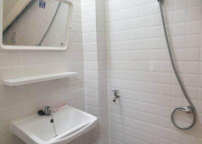 Small bathroom with sink, mirror, and shower