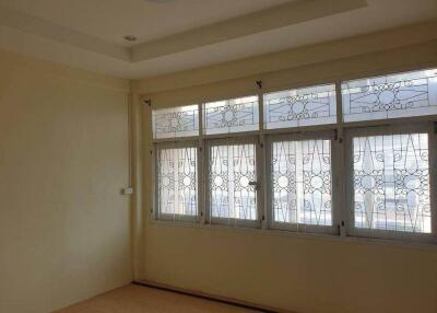 A well-lit bedroom with large windows and decorative grills