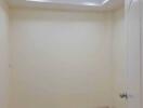 Empty room with beige walls and recessed lighting