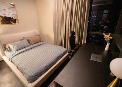 Bedroom with bed, desk, chair and night view through window