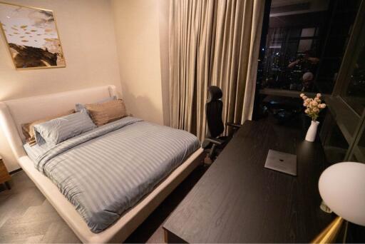 Bedroom with bed, desk, chair and night view through window