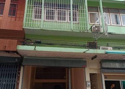 Front view of a multi-story residential building with green facade