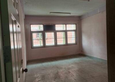 Empty bedroom with large window and tiled floor