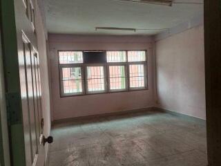 Empty bedroom with large window and tiled floor