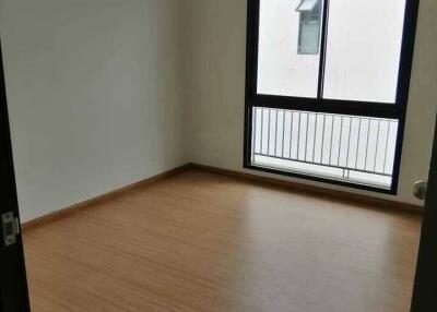 Empty bedroom with wooden flooring and a large window