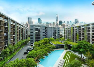 Apartment complex with large pool and city skyline