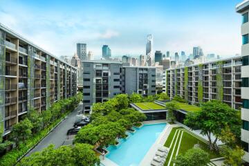 Apartment complex with large pool and city skyline