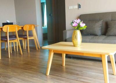 Living room with a grey sofa, wooden coffee table, and dining set