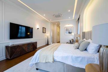 Spacious and modern bedroom with a large bed, TV, and elegant decor