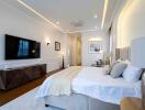 Spacious and modern bedroom with a large bed, TV, and elegant decor