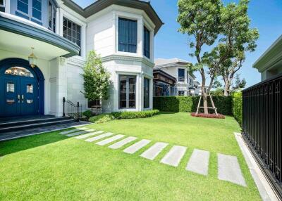 Front exterior view of a modern house with a well-maintained lawn