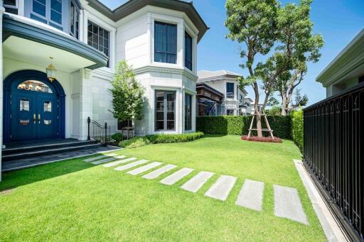 Front exterior view of a modern house with a well-maintained lawn