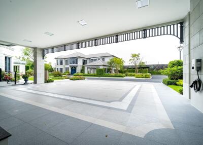 View of a spacious and modern house exterior with a large driveway and landscaped garden