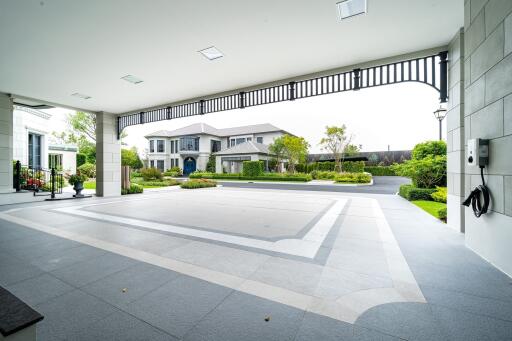 View of a spacious and modern house exterior with a large driveway and landscaped garden