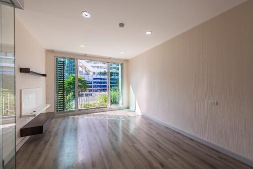 Spacious living room with large windows and wooden flooring